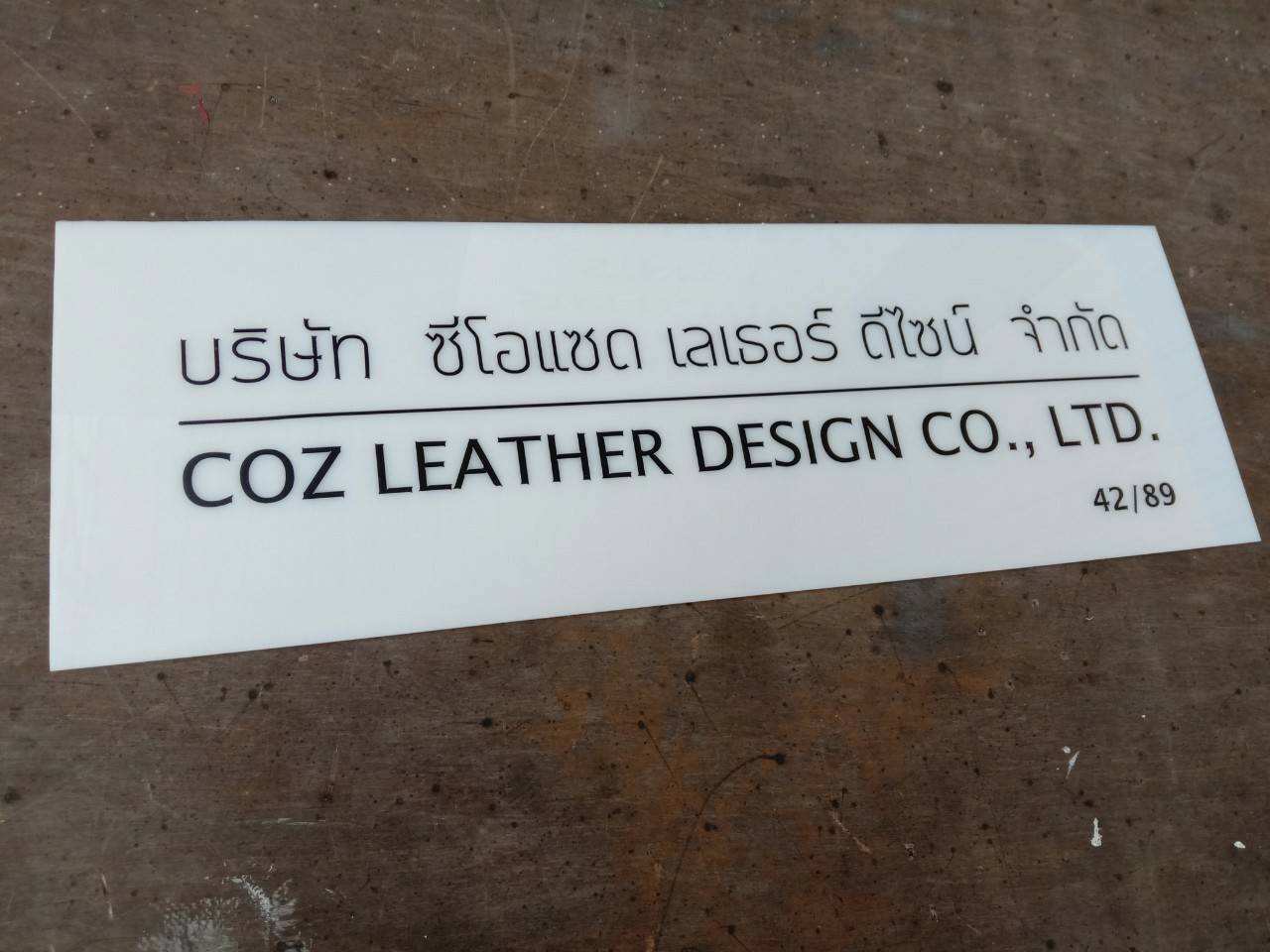 ป้ายอะคริลิคสีขาว หน้าติดสติ๊กเกอร์สีดำไดคัท บริษัท ซีโอ เลเธอร์ ดีไซน์ จำกัด